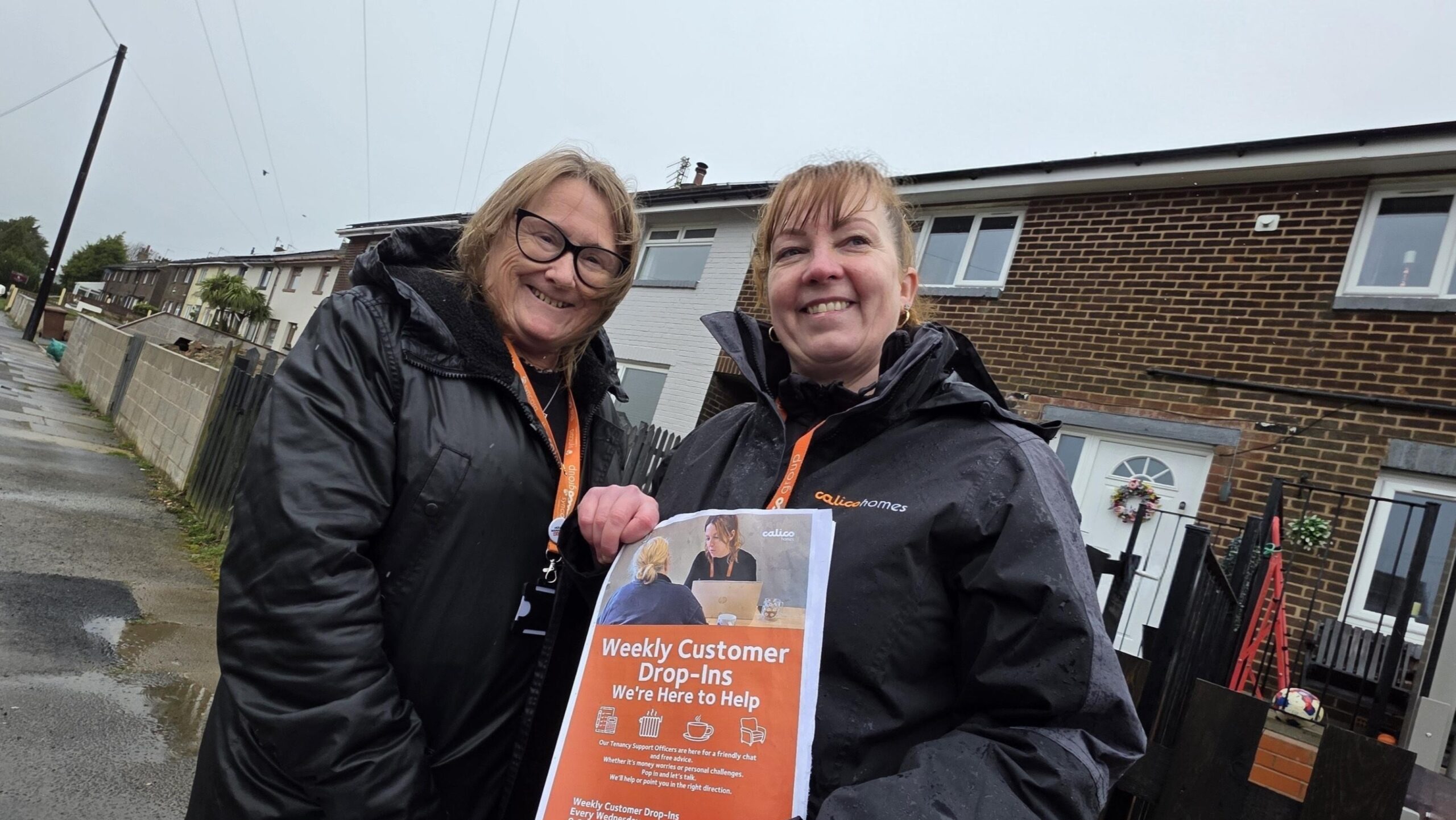 Two Calico employees out in the community on a rainy day.