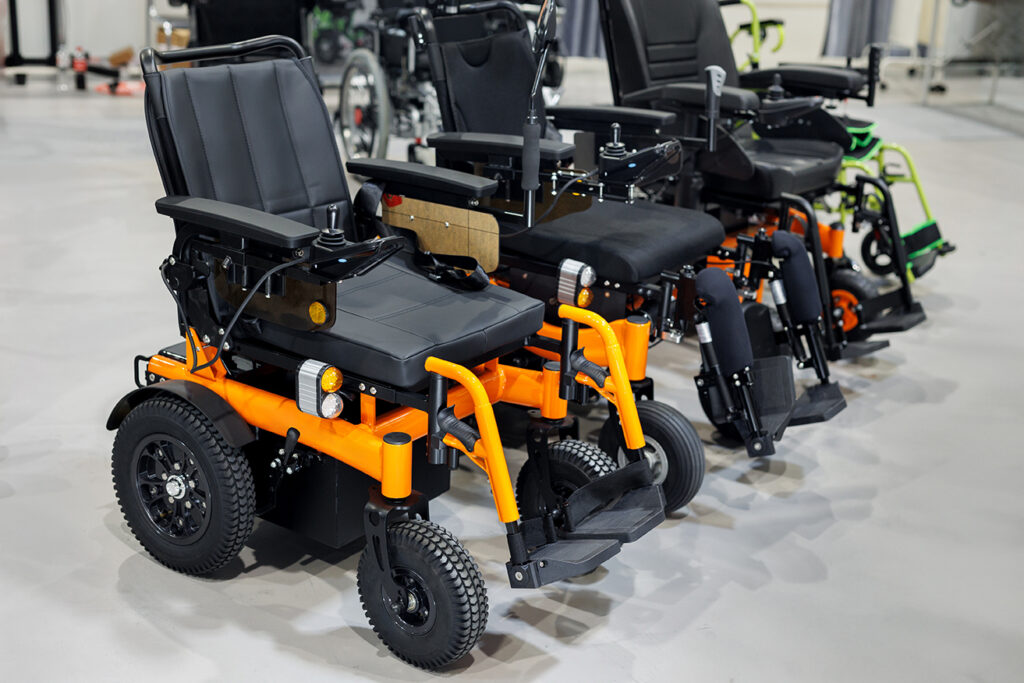 Several powered wheelchairs displayed indoors, showing mobility equipment used for accessible and independent travel.